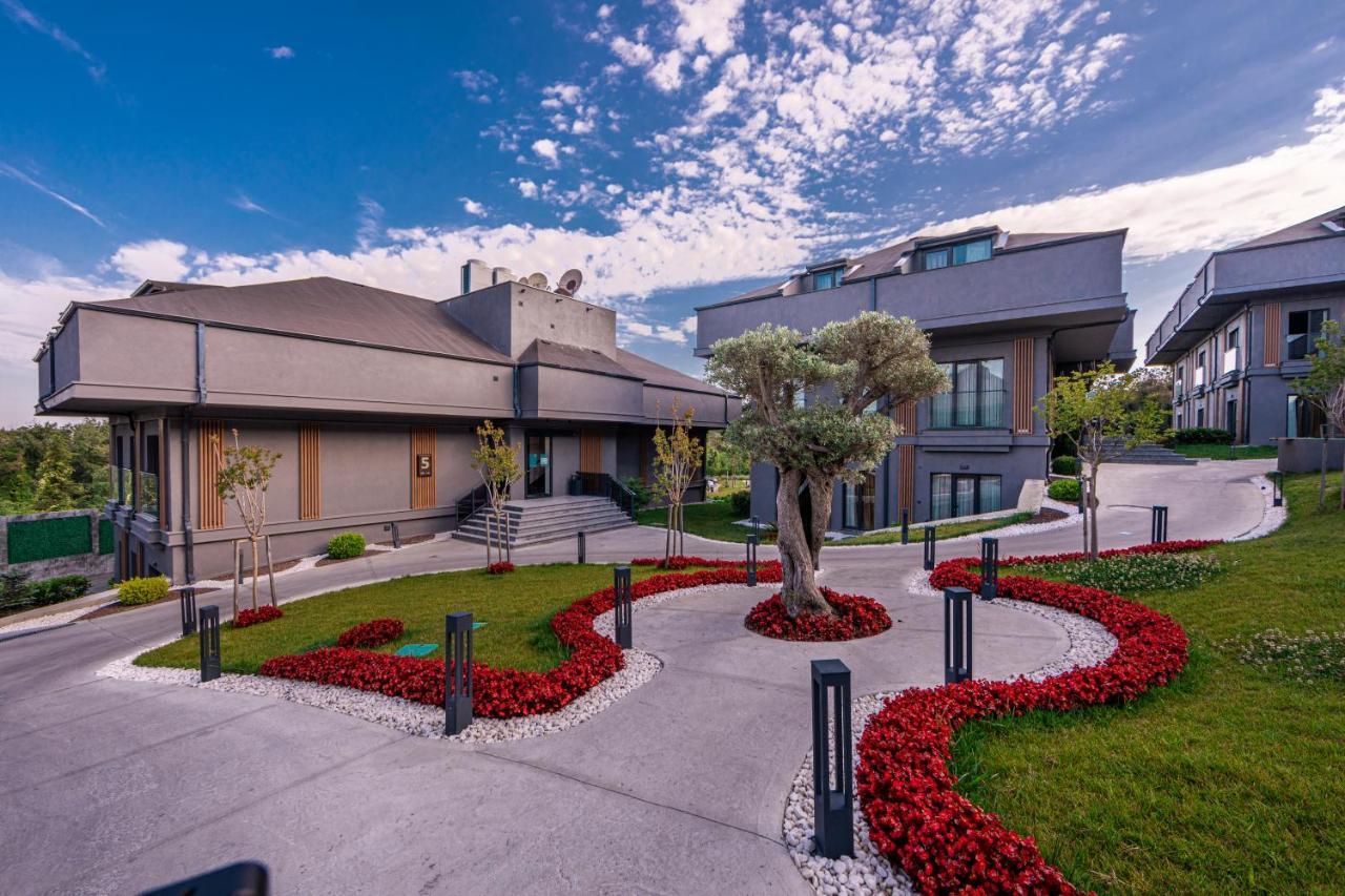 Menalo Hotel Premium Istanbul Airport Exterior foto The photo shows a modern architectural setting, featuring two distinct buildings. The first structure is a larger, grey building with a flat roof and multiple levels, while the second building is slightly smaller and has a more angular design. 

In t